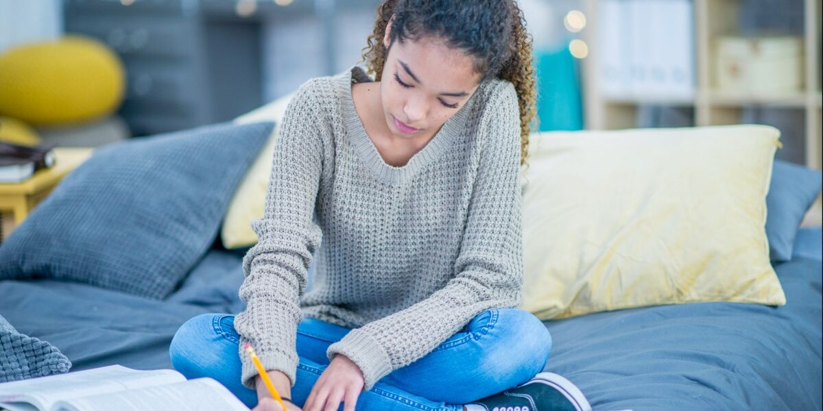 iStock-1030960364_girl-studying-on-bed